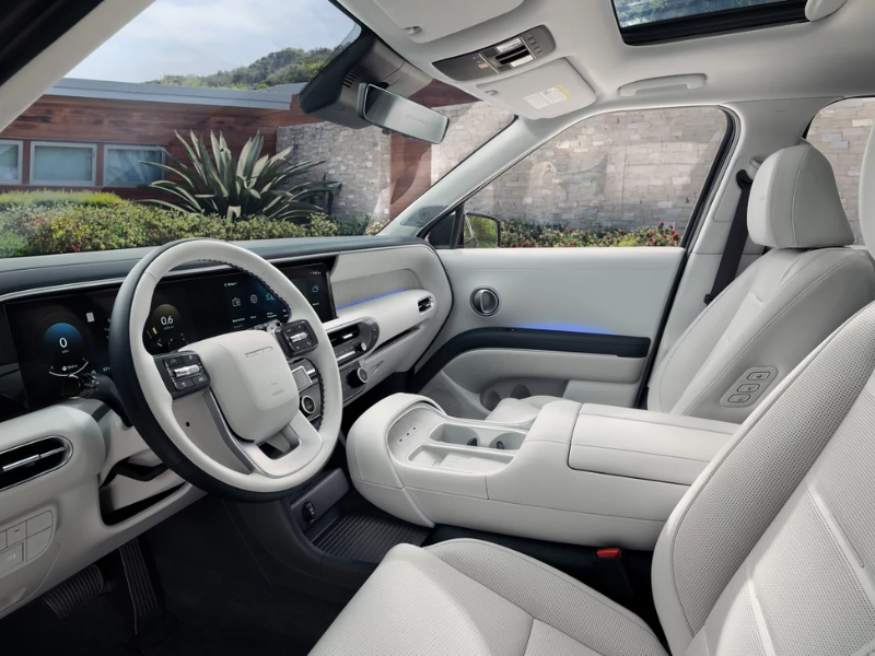 Interior of the Hyundai Palisade Hybrid showing the twin 12.3-inch screens and three rows of seating