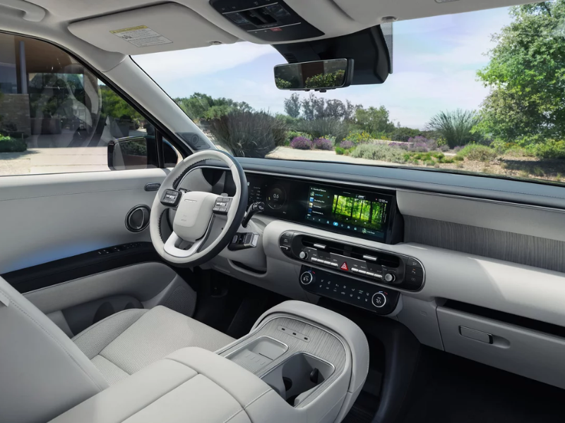 Interior of the Hyundai Palisade Hybrid showing the twin 12.3-inch screens and second-row captain's chairs